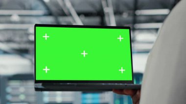 Veri merkezindeki teknisyen güncelleme ekipmanlarını izole ekran bilgisayarı kullanarak kapat. Yüksek teknolojili işletmelerde bilişim uzmanı, sunucu sıralarını krom anahtar not defteri, kamera B ile denetliyor.