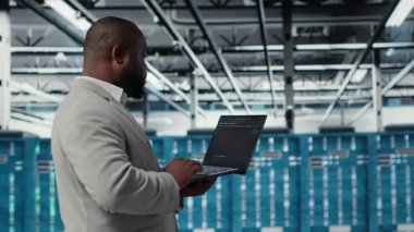 Sunucu odası altyapı mühendisi bilgisayardaki yazılımı kullanarak otomatik iş akışları betiği yapıyor. Veri merkezi programcısı öngörücü bakım taramaları yapıyor. Not defteri, kamera B kullanarak.