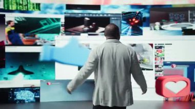 Neşeli kullanıcı modern dijital ortamda sınırsız eğlencenin tadını çıkarıyor. Mutlu adam dev dijital duvarın önünde duruyor çevrimiçi videolar ve sosyal medya içeriği, kamera A