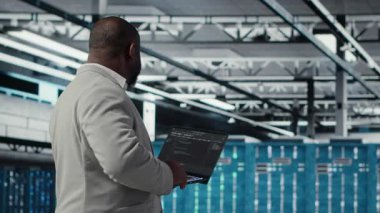 Neşeli veri merkezi sistem yöneticisi otomasyon senaryoları kodunu gözden geçiriyor. Jolly sunucu odası çalışanı ekipman üzerinde tanılama yapıyor, öngörü hatası algılaması yapıyor, kamera B