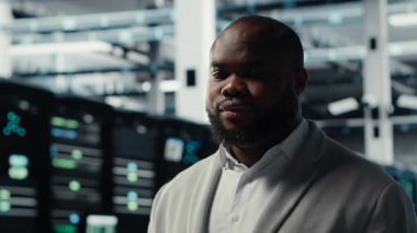 Gülümseyen sunucu odası mühendisi dizüstü bilgisayardaki yazılımı kullanarak sunucu raflarında bakım yapıyor. Happy data center IT profesyonel bıçaklı sunucu bileşenlerini not defteri, kamera B kullanarak güncelliyor