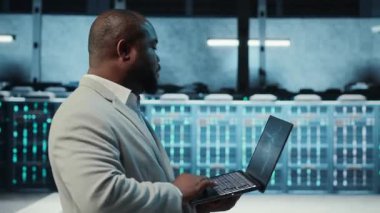 Sunucu odasında yönetici, dizüstü bilgisayarında kontrol listesiyle dolaşmak, sorun çıkaran donanım. Sunucu merkezinde denetleme yapıyor, altyapı performansını denetliyor, kamera B