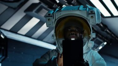 Astronot araştırmacı, araştırma yapmak için tablet kullanıyor. Uzay gemisinde kozmonot teçhizatı giyen bilim adamı uçuş sırasında yaşam destek sistemlerini izleme cihazı, kamera B 'yi kullanarak