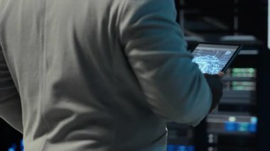 Sistem yöneticisi, modern süper bilgisayar birimleriyle dolu duvarlarla veri merkezine giriyor. Bilgi işlem uzmanı sunucu çiftliğini düzeniyle denetliyor iş teknolojisi ihtiyaçlarını destekliyor, kamera B