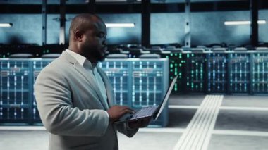 Sunucu odasında yönetici, dizüstü bilgisayarında kontrol listesiyle dolaşmak, sorun çıkaran donanım. Sunucu merkezinde denetleme yapıyor, altyapı performansını denetliyor, kamera A