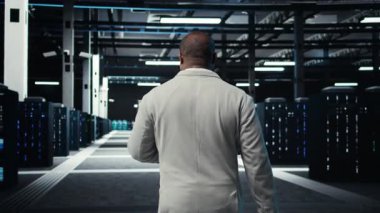 Veri merkezinde dizüstü bilgisayar kullanan teknisyen, sunucu viralizasyonunu yöneten, betikleri çalıştıran. Bilgi İşlem uzmanı sunucu merkezinde dizüstü bilgisayarda programlama dili kullanıyor, ağ protokollerini inceliyor, kamera A