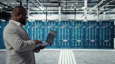 Not defteri kullanılarak kaynak optimizasyonu için veri merkezi geliştiricisi kod yazıyor. Sunucu odası mühendisi, laptop ve kamera A 'daki yazılımı kullanarak üst zamanı iyileştirmek için yeni binalar açıyor.