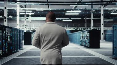 Sistem yöneticisi, veri merkezinde sırayla, tam işlevsel çarklarla yürüyor. İş depolama altyapısı için inşa edilmiş sunucu çiftliğini denetleyen bilişim uzmanı, kamera A