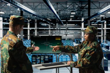Ordu askerleri veri merkezinde düşman hedeflerine kilitlenmek için dijital hedefler kullanıyorlar. Sunucu merkezi komuta odasındaki askeri birimler monitördeki taktik yazılım ekranına bakıyor.
