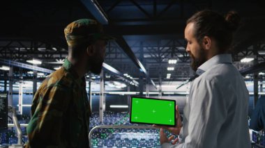 Military technicians in data center use green screen mockup tablet to monitor systems. Army operators in server room ensuring stable infrastructure using chroma key device,