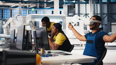 Güneş panellerindeki Afrikalı Amerikalı teknisyenler VR gözlük kullanarak tesis kuruyor CAD yazılımı kullanarak yerleşimleri optimize ediyorlar. Fotovoltaik fabrika işçisi sanal gerçeklik teknolojisini kullanarak düzenlemeler yapıyor. Kamera B.