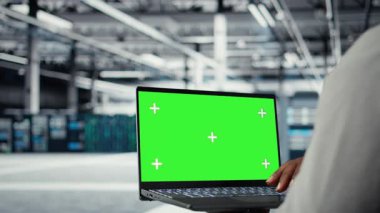 Veri merkezindeki teknisyen güncelleme ekipmanlarını izole ekran bilgisayarı kullanarak kapat. Yüksek teknolojili işletmelerde bilişim uzmanı, sunucu sıralarını krom anahtar defteri, kamera A ile denetliyor.