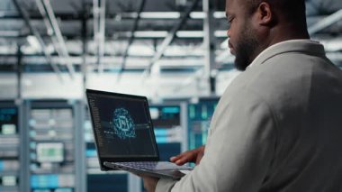 Veri merkezindeki yazılım geliştiricisi depolama hacmini optimize etmek için dizüstü bilgisayardaki yapay zeka teknolojisini kullanır. Sunucu merkezi tesisinde bilişim uzmanı. Kusursuz operasyonlar için yapay zeka kullanıyor. Kamera B: