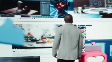 Adam, video ve sosyal medya videoları ile çevrili dijital video baykuşağının önünde duruyor. Kullanıcı, multimedya gösterge paneli, kamera A üzerinden anında binlerce eğlence seçeneğine erişiyor