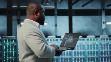 Veri merkezindeki yazılım geliştiricisi yeni sunucu mimarileri için dizüstü bilgisayardaki yapay zeka teknolojisini kullanıyor. Yapay zeka teknolojisi, kamera B kullanılarak depolama dizilerini güncelleyen sunucu merkezi bilişim uzmanı