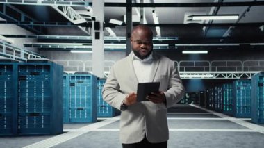 Veritabanında tablet kullanarak gülümseyen yönetici iş yükleri için altyapıyı koruyor. Sunucu çiftliğindeki neşeli bilişim uzmanı paralel işlemler için yüksek teknoloji sunucu kümeleri kullanıyor, kamera A