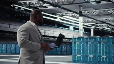 Neşeli veri merkezi sistem yöneticisi otomasyon senaryoları kodunu gözden geçiriyor. Jolly sunucu odası çalışanı ekipman üzerinde tanılama yapıyor, öngörü hatası algılaması yapıyor, kamera A