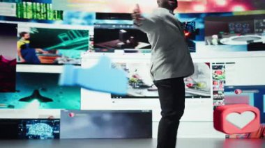 Online medya dünyasına girmekten memnun olan adam binlerce video kaydına erişebiliyor. Çeşitli internet içeriğini vurgulayan video önizlemeleri ile çevrili mest edici kullanıcı, kamera A