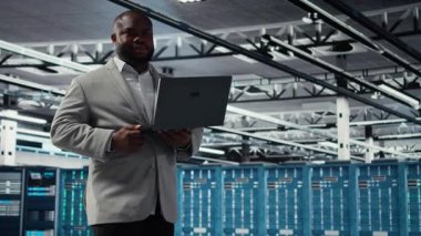 Yönetim veri merkezindeki endüstriyel platformda yürüyor. Dizüstü bilgisayardaki altyapı performans çıktılarını analiz ediyor. Sunucu çiftlik işçisi iş görevleri yapıyor, ana bilgisayarları inceliyor, ayarlar, kamera A