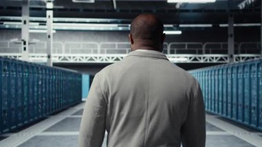 Veri merkezindeki sistem yöneticisi altyapı teknisyenlerinin kullanıcı taleplerini denetliyor. Sunucu tarlasında çalışan Afrikalı Amerikalı işçiler trafik ekipmanları ve kamera A 'yı inceliyor.