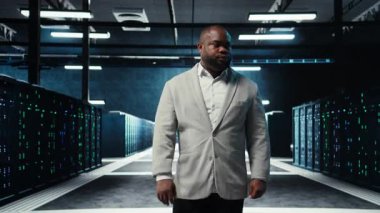 Çalışan veri merkezinde sistem faaliyeti gösteren platformlarda yanıp sönen ışıklarla yürüyor. Bilgi İşlem Uzmanı, loş ışıklandırmalı sunucu çiftliği, düzgün işlemler için düzenlenmiş ekipman, kamera A