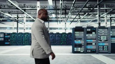 Sistem yöneticisi veri merkezinde sorguları kontrol eden platformlarla yürüyor, yedekleme yapıyor. Dijital hizmetlere ev sahipliği yapan, müşteri platformlarına güç veren sunucu çiftliği yönetimi, kamera A