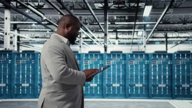 Keyifli sunucu odası mühendisi tablet üzerinde yazılım kullanarak arka uç işlemleri yapıyor. Jolly veri merkezi programcısı, aygıt, kamera A kullanarak hataları düzeltmek için yazılım yamaları derliyor