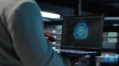 Sunucu odası yönetimi, altyapı yapay zeka makinesini otomatik hale getirmek için dizüstü bilgisayar kullanıyor. Veri merkezinde yürüyen yazılım geliştiricisi yapay zeka ve kamera B kullanarak bakım yapıyor.