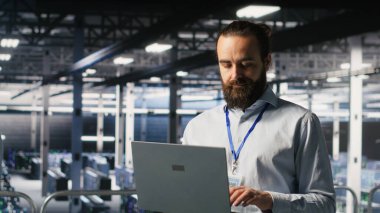 Bilgisayar bilimcileri veri merkezi endüstriyel platformunda dizüstü bilgisayardaki performans çıktılarını analiz ediyorlar. Sunucu çiftliği bilişim uzmanları ince ayar yapılandırmalarında işbirliği yapıyor