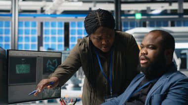 Afrika kökenli Amerikalı usta mühendisler güneş enerjisi fabrikasındaki fotovoltaik aktiviteleri inceliyor, üretim süreci için veri ve kontrol listelerini gözden geçiriyorlar. Çevre dostu yenilenebilir enerji. Kamera B.