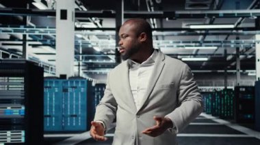 Yüksek teknoloji veri merkezi tesisinde çeşitli işlevsel sunucu raflarıyla yürüyen bir yönetici. Dijital depolama sistemleri için kurulmuş sunucu merkezini denetleyen denetleyici, kamera A