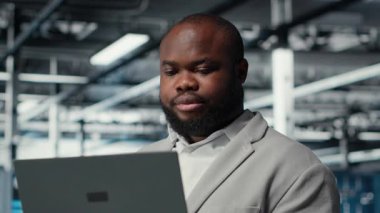 Bilgisayar kullanarak sunucu odasındaki mühendisi kapat, güvenlik yamalarını çalıştır, güvenlik duvarı yapılandırmalarını doğrula. Veri merkezinde ekipman hassasiyeti taraması yapan işçiler, kamera B