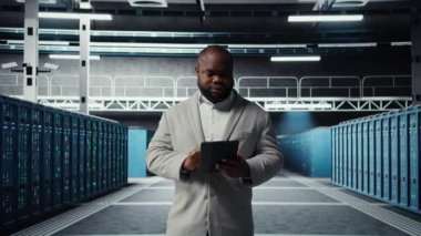 Verimli veri analizi için sunucu çiftliğinde yürüyen bir sistem yöneticisi. Veriler için depolama sistemlerini yöneten bir merkezde aygıt kullanan işçiler, kamera A