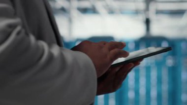 Enerji kullanımını ayarlamak için tablet kullanarak veri merkezindeki işyerindeki yöneticiyi kapat. UPS yapılandırmalarını denetlemek için aygıt kullanan sunucu odası bilişim uzmanı, ekipmanların bakımını yapıyor