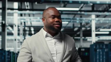 Yüksek teknoloji veri merkezi tesisinde çeşitli işlevsel sunucu raflarıyla yürüyen bir yönetici. Dijital depolama sistemleri için kurulmuş sunucu merkezini denetleyen denetleyici, kamera B