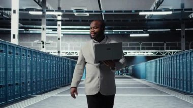 Gülümseyen sunucu odası mühendisi dizüstü bilgisayardaki yazılımı kullanarak sunucu raflarında bakım yapıyor. Happy Veri Merkezi IT profesyonel bıçak sunucu bileşenlerini not defteri, kamera A kullanarak güncelliyor