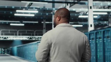 Sistem yöneticisi, veri merkezinde sırayla, tam işlevsel çarklarla yürüyor. İş depolama altyapısı için inşa edilmiş sunucu çiftliğini denetleyen bilişim uzmanı, kamera B