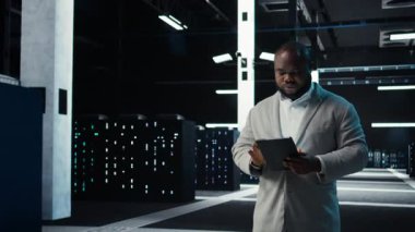 Veri merkezinde felaket kurtarma planlarını geliştirmek için tablet kullanan bir yönetici. Sunucu çiftliğinde yürüyen bilişim uzmanı, arıza senaryolarını test ediyor, bozulmalar sırasında verileri koruyor, kamera A