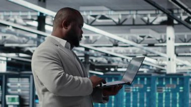 Gülümseyen veri merkezi teknisyeni donanım bileşenlerini yüklüyor ve geliştiriyor. Happy sunucu çiftlik çalışanı iş görevleri yapıyor, veri kaybına karşı korumak için yedek çözümler uyguluyor, kamera B