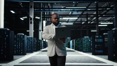 Bilgisayar kullanarak veri merkezinde programcı, ekipman arızası senaryolarını test ediyor. Sunucu çiftliği bilişim uzmanı defter üzerinde yazılım kullanıyor, veri erişiminin sağlanması, kamera A