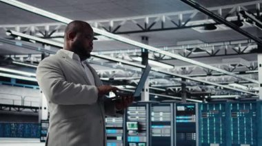 Gülümseyen veri merkezi teknisyeni donanım bileşenlerini yüklüyor ve geliştiriyor. Happy sunucu çiftliği çalışanı görev yapıyor, veri kaybına karşı korumak için yedek çözümler uyguluyor, kamera A