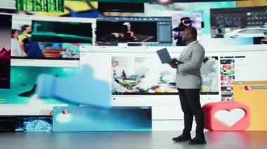 Neşeli adam dizüstü bilgisayarında yayın yapıyor, kişisel video tavsiyeleri alıyor. Not defteri kullanan iyimser kullanıcı, çok çeşitli çevrimiçi kliplere erişimin keyfini çıkarıyor, kamera A