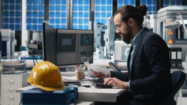 Bir güneş teknolojisi fabrikasında üretim verilerini inceleyen erkek endüstrisi uzmanı alternatif enerji başarısını sürdürmek için yenilik ve verimliliği garanti altına alıyor. Gelişim için sürdürülebilir çözümler. Kamera B.