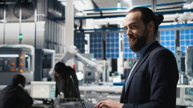 Güneş panelleri endüstri teknisyeni. Yüksek teknoloji ürünü bir fabrikada denetleme, kalite kontrol ölçümleri için. Profesyonel mühendis verimlilik için endüstriyel operasyonları sağlıyor. Kamera A.