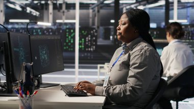 Sinirli veri merkezi çalışanı iş yerindeki anlaşmazlık sırasında meslektaşına kaba bir el hareketi yapıyor. Sunucu merkezindeki kızgın kadın tartışma sırasında iş arkadaşını hiçe sayıyor. Kamera A: