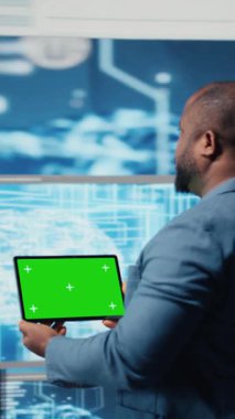 Dikey Video Afrikalı Amerikalı bilişim uzmanı arka planda krom anahtar ekranlı tablet ve terminal pencereli dijital dönüşüm gösteriyor. Veri bilimi ile yazılım geliştirme gösterimi