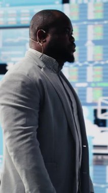 Dikey Video Siyah girişimci CEO 'su profesyonel bir fintech kongresinde katılımcılar için sahnede bir iş konuşması yapıyor. Başarı için bilgi grafikleri sunan güçlü bir sesle.