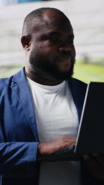 Web platformlarında canlı dijital arayüzler ve veri görselleştirmeleri ile bağlanan dikey video yüksek teknolojili siyah kullanıcı mobil ağ bağlantısını gösteriyor. Sosyal medya deneyimi. Kamera B.