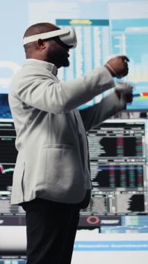 Fon elde etmek için sanal gerçeklik kulaklığıyla çalışan Dikey Video İş Lideri, kalkınma planı için ön panel performans raporlarını gözden geçiriyor. Maddi durumu analiz etmek için 3D simülasyon