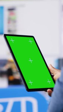 Dijital arayüzler ve multimedya görsellerinin yanındaki kroma anahtar ekranına bakan dikey video Afrikalı Amerikalı teknoloji meraklısı, içerik oluşturma, mobil teknoloji ve küresel çevrimiçi